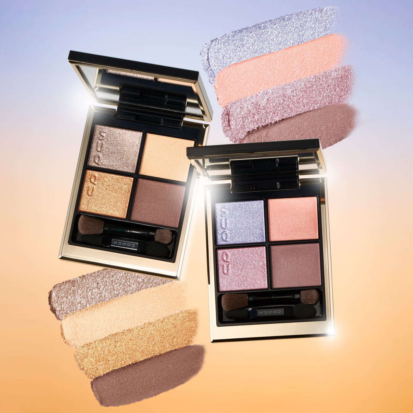 SUQQU 2026 Summer Collection, multiple beautiful colourful luxury makeup products on a gradient sky background. Two eyeshadows with gold and pink coral tones with colour texture swatches.
