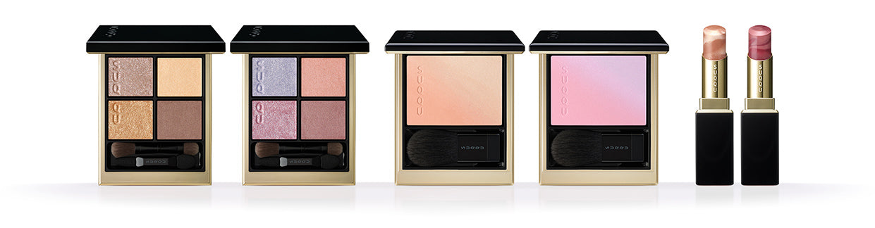 SUQQU 2026 Summer Collection colourful luxurious makeup products standing in a line. Including two beautiful quad eyeshadow palettes, two cheek blusher / highlighters and two lispticks. SUQQU - The highest quality skincare and cosmetics from Japan.