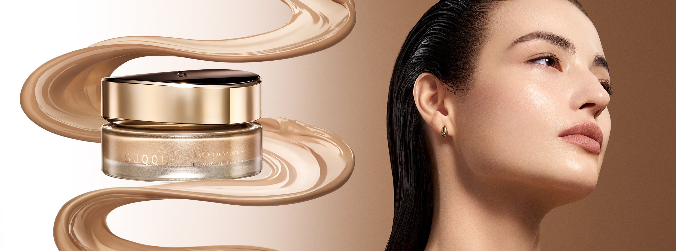 A SUQQU 'The Foundation e' jar with a gold cap and beige foundation cream swirls on a warm beige background, alongside a close-up of a woman's radiant and flawless face complexion.