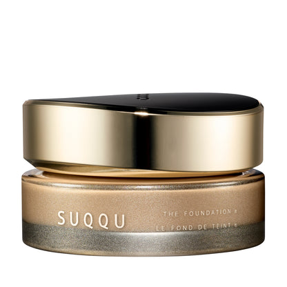SUQQU The Foundation e 030 luxury cream base makeup jar on plain white background with gold and black lid and frosted glass base. Light to Medium beige cream foundation shade.