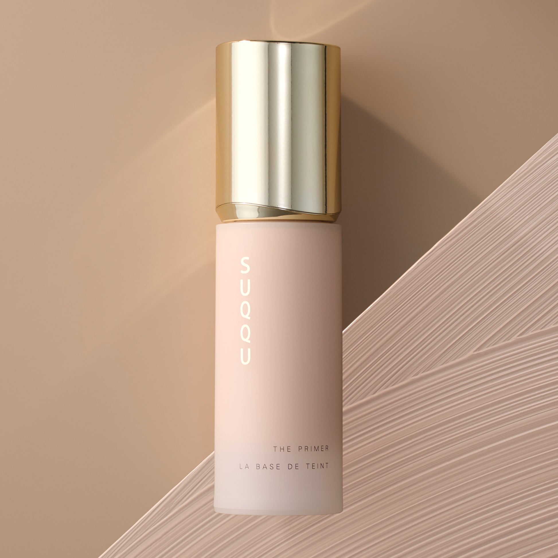 SUQQU The Primer luxury base make up product bottle on background with texture swatch.