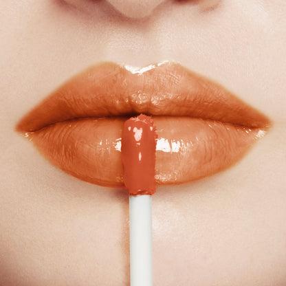 SUQQU Treatment Wrapping Lip gloss wand with model wear lip close up of colour and glossy texture.
