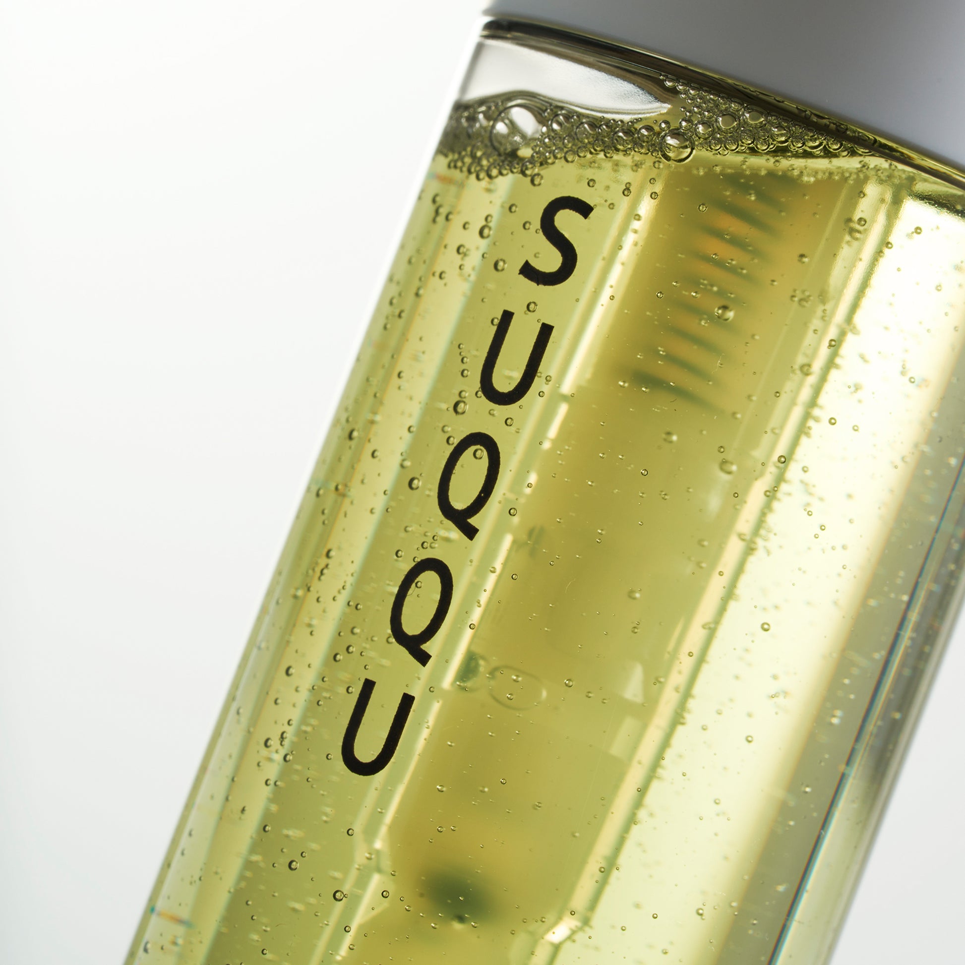 SUQQU UV Protect Mist Naginokou SPF 50 reliable Japanese premium sun care pump bottle close up in sunlight.