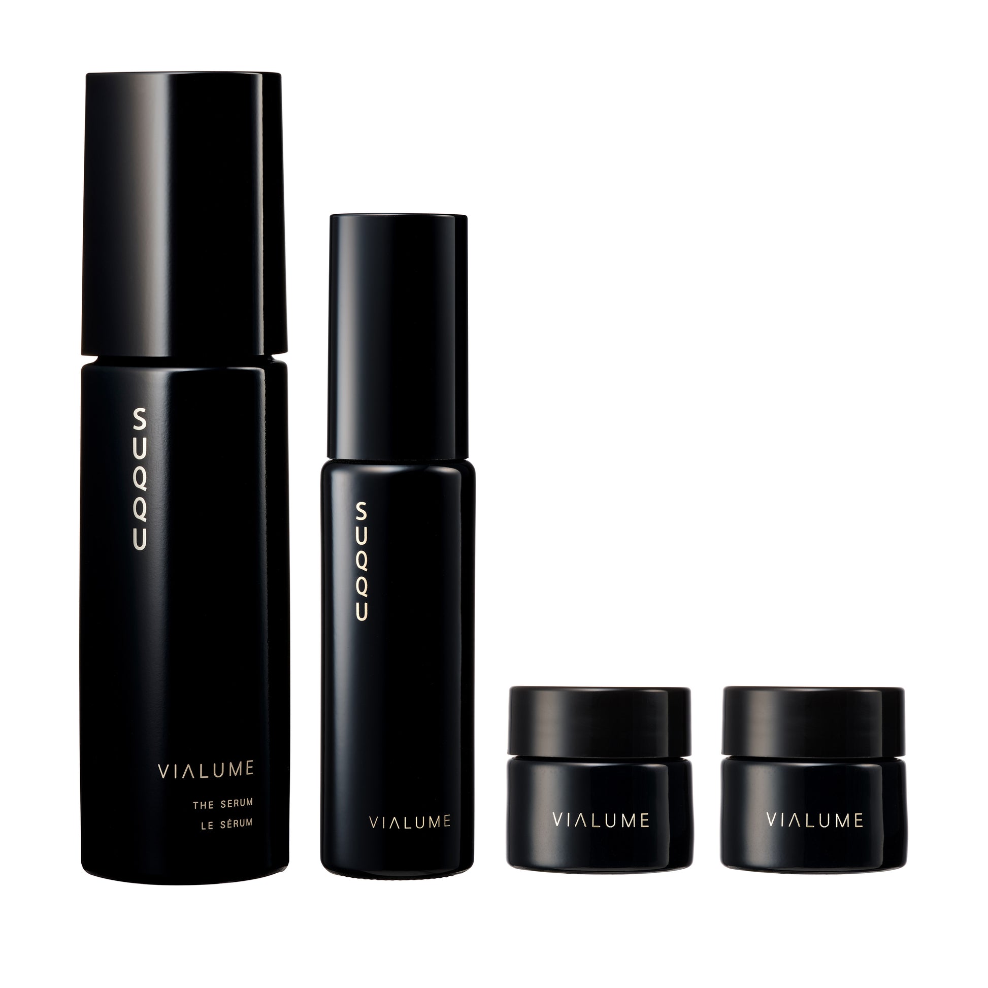 SUQQU Vialume The Kit C four luxury Japanese skincare products on a plain background. Serum, lotion, anti-ageing cream and face cream moisturisers.