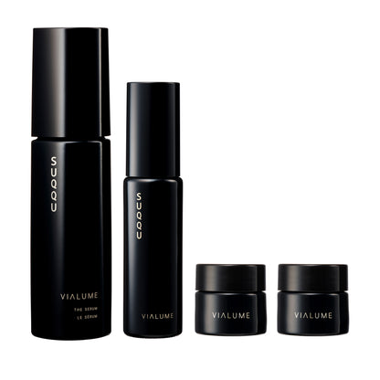 SUQQU Vialume The Kit C four luxury Japanese skincare products on a plain background. Serum, lotion, anti-ageing cream and face cream moisturisers.
