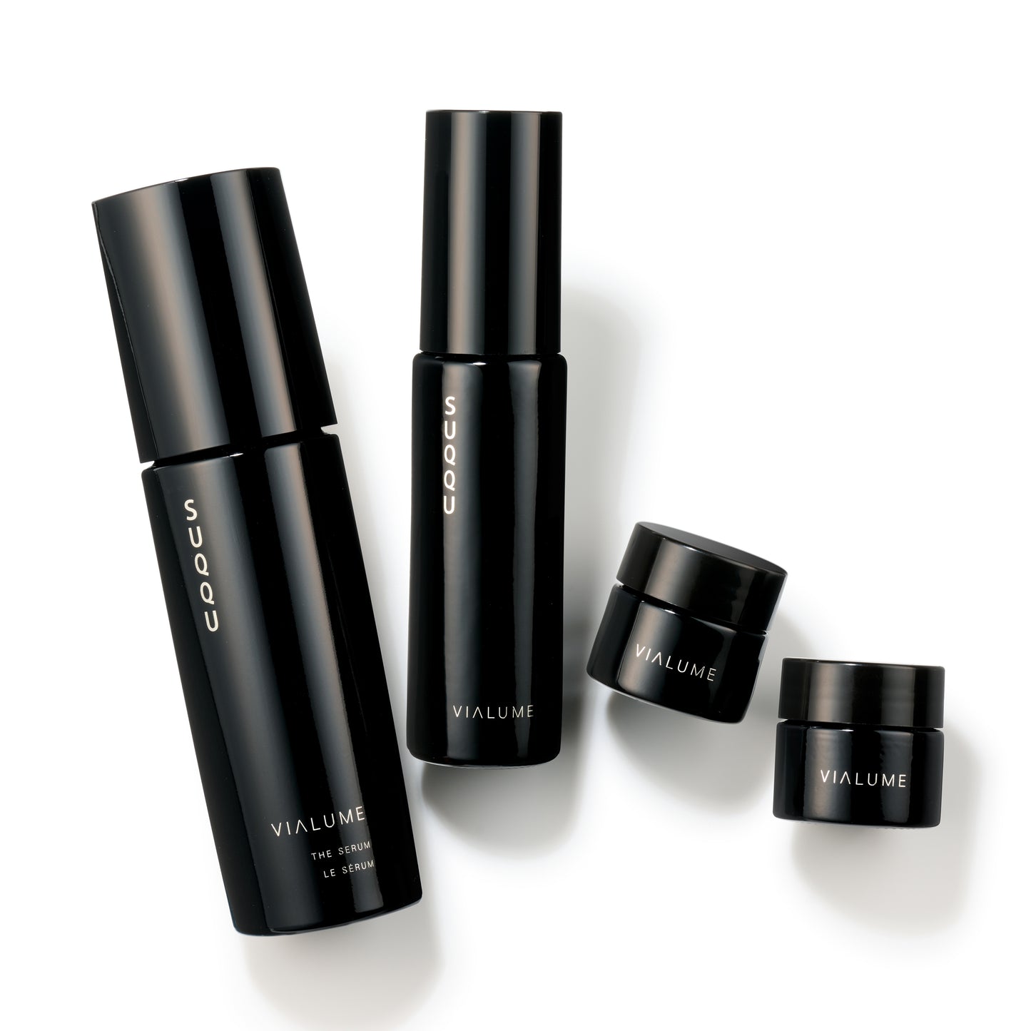 SUQQU Vialume The Kit C four luxury Japanese skincare products on a plain background. Serum, lotion, anti-ageing cream and face cream moisturisers.