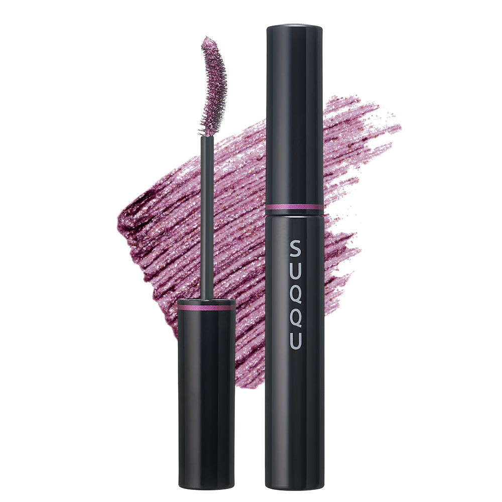 A black SUQQU Nuance Mascara 101 Amethyst Purpl shade mascara tube with the cap removed, showing the applicator wand and a glittery mauve-pink product swatch behind it on a white background. The tube has a purple band and vertical 'SUQQU' branding.